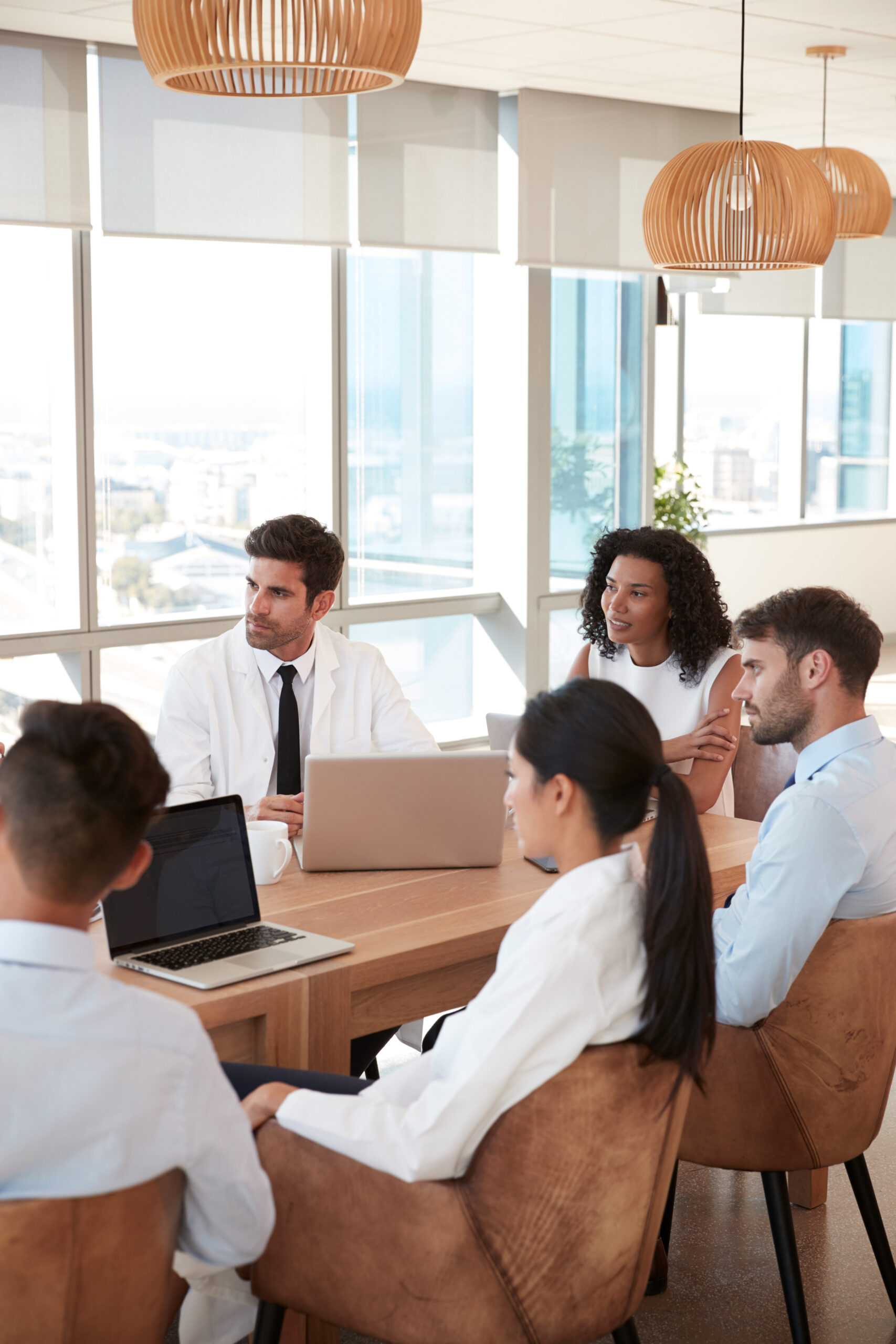 Group Of Medical Staff Meeting Around Table In Hospital