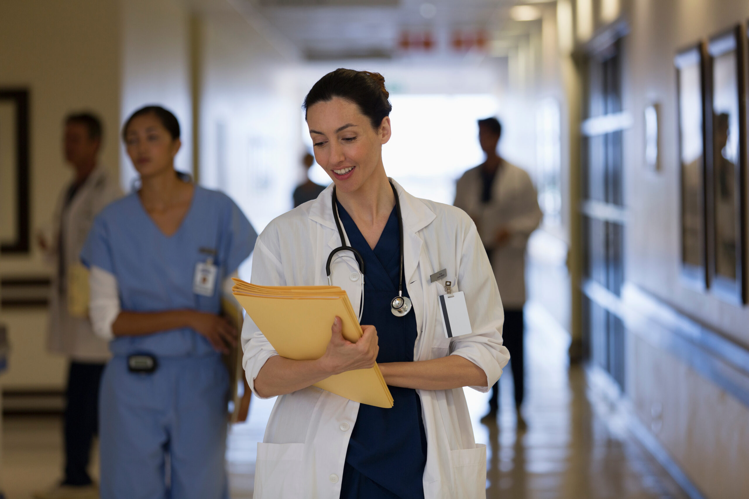 Female doctor making rounds in hospital corridor