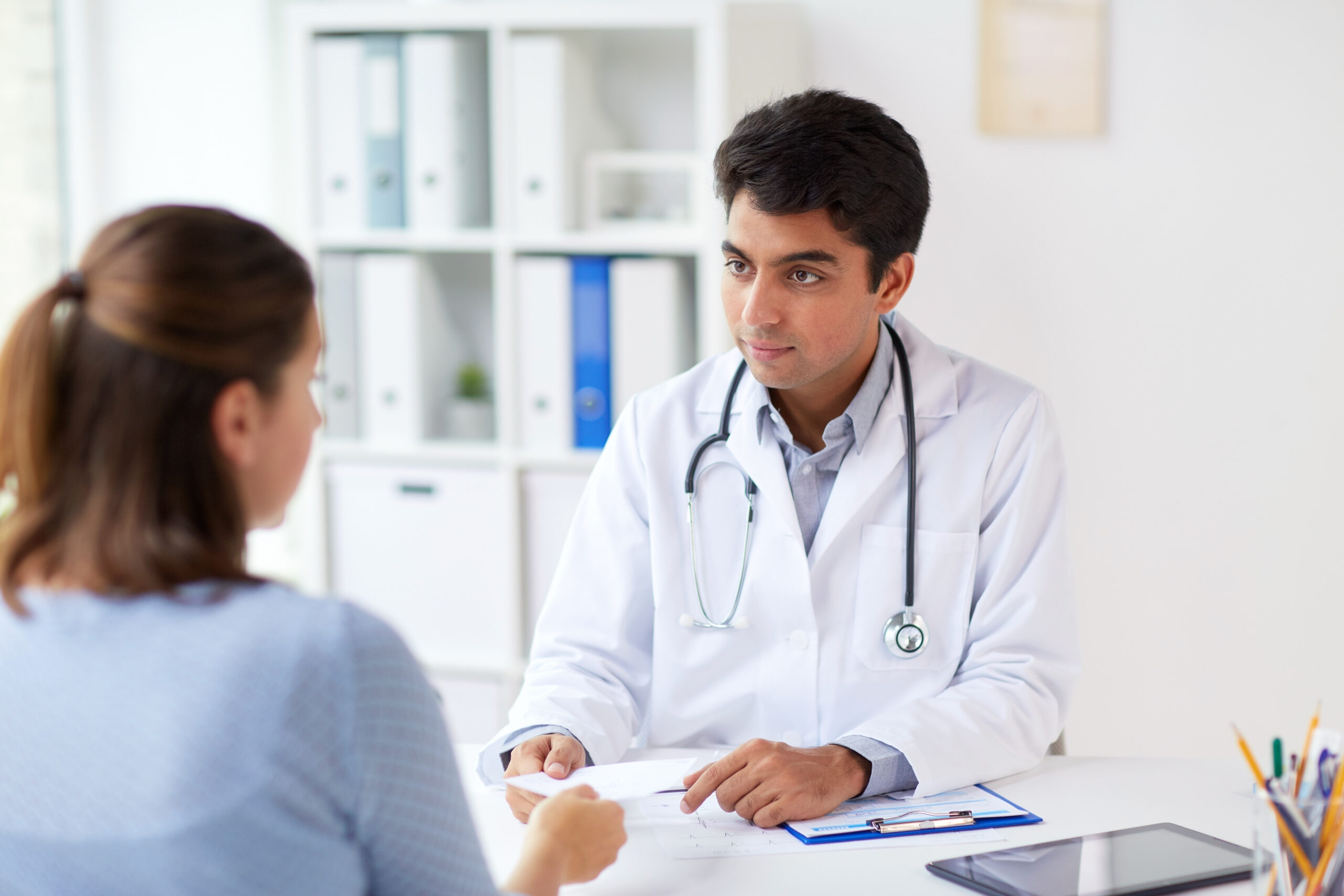 doctor giving prescription to patient at hospital